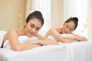 two cute young women during skin care treatment spa