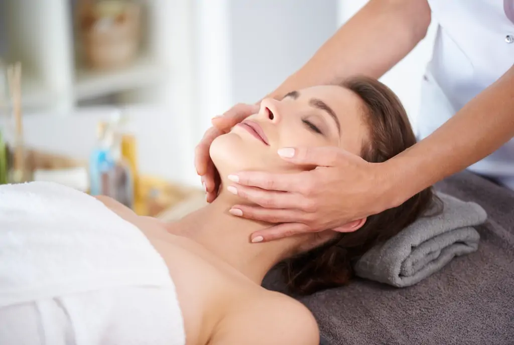 young female receiving professional facial massage
