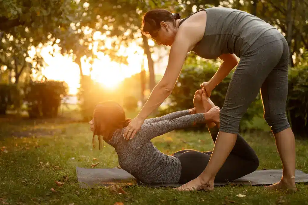 full shot women doing yoga outdoors